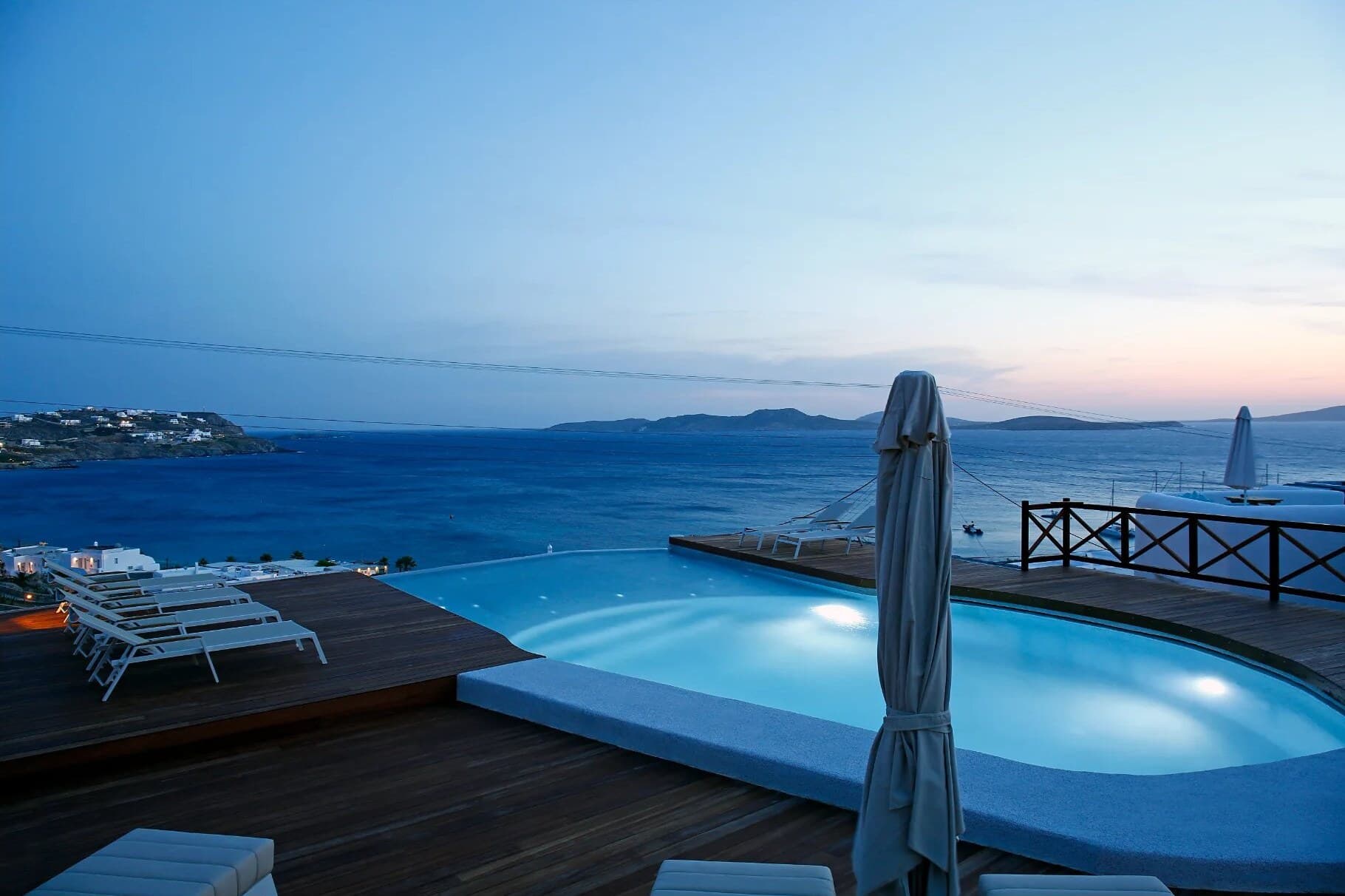 Pool and wooden deck at dusk overlooking the bay