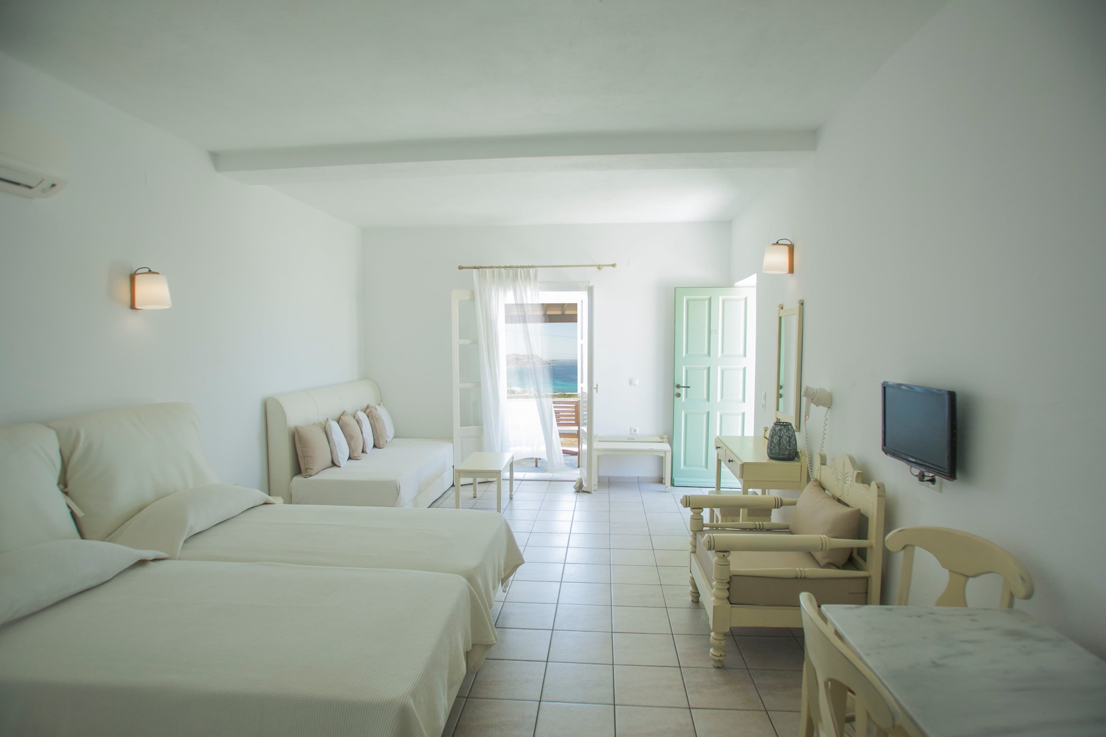 Studio beds facing the television and open outdoor doors