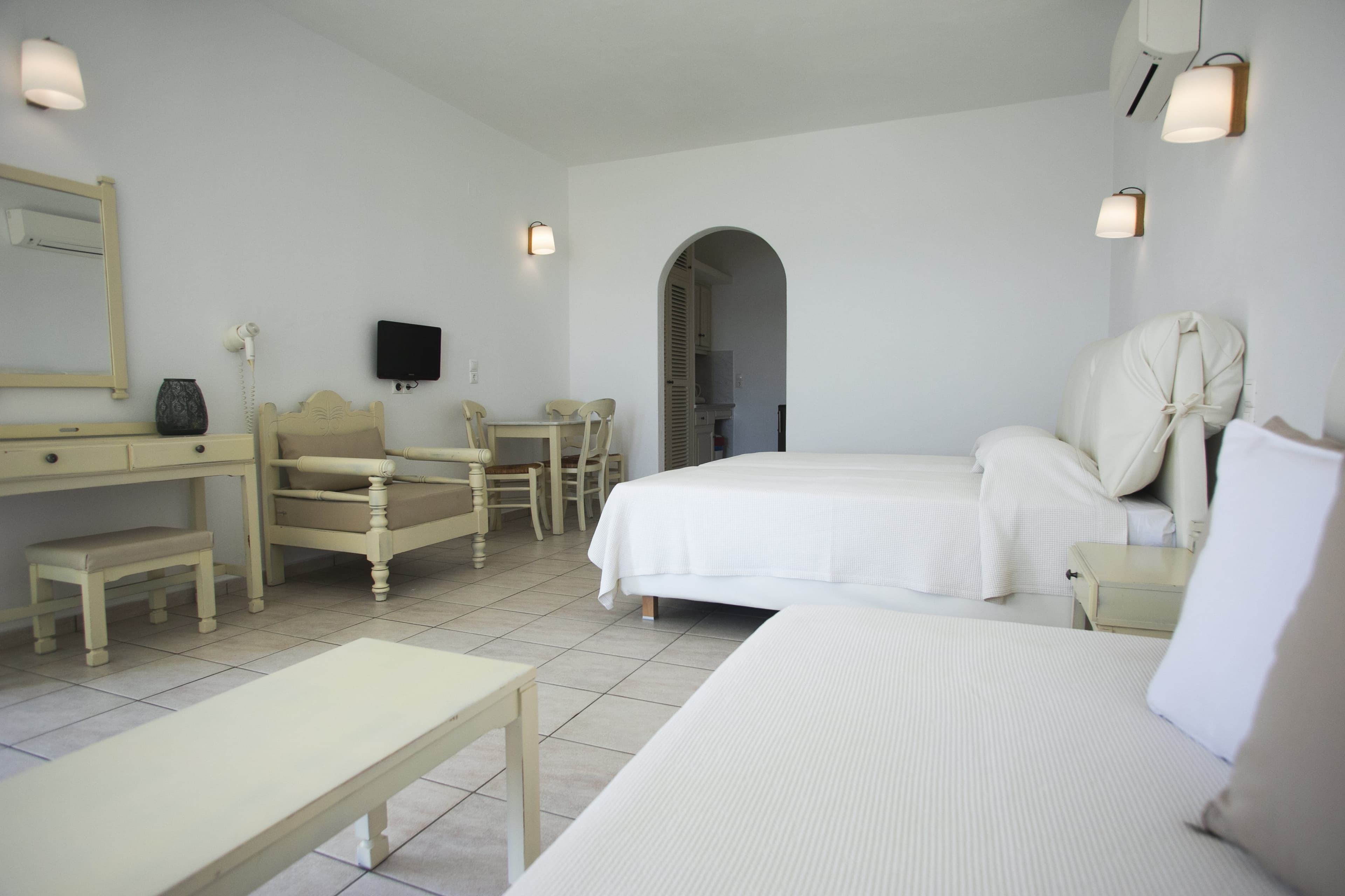 Studio beds and seating beside a dressing table and arched doorway
