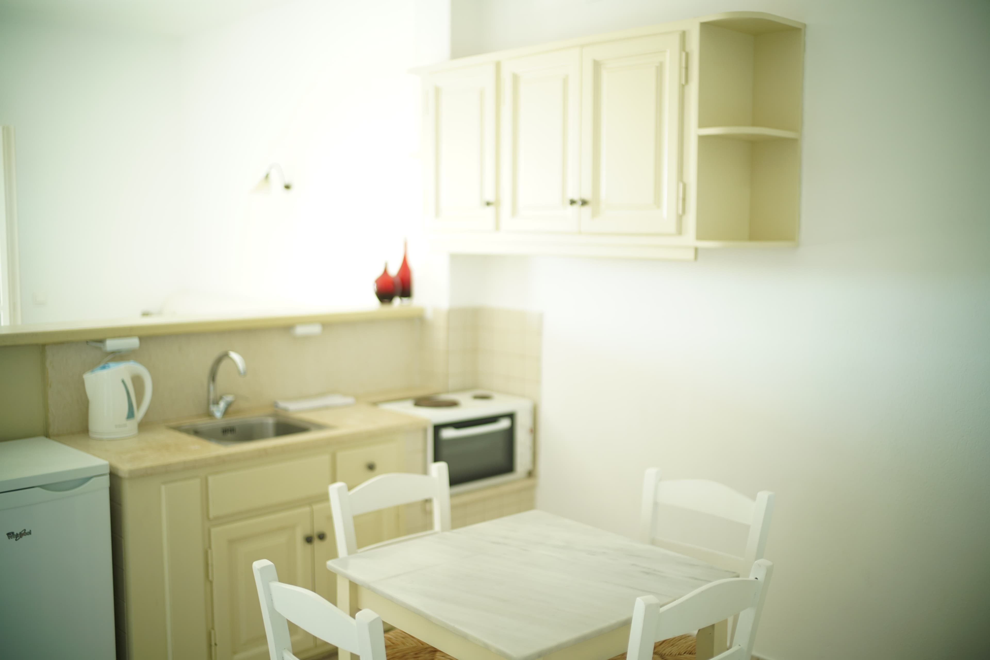 White kitchenette and dining table beside the window