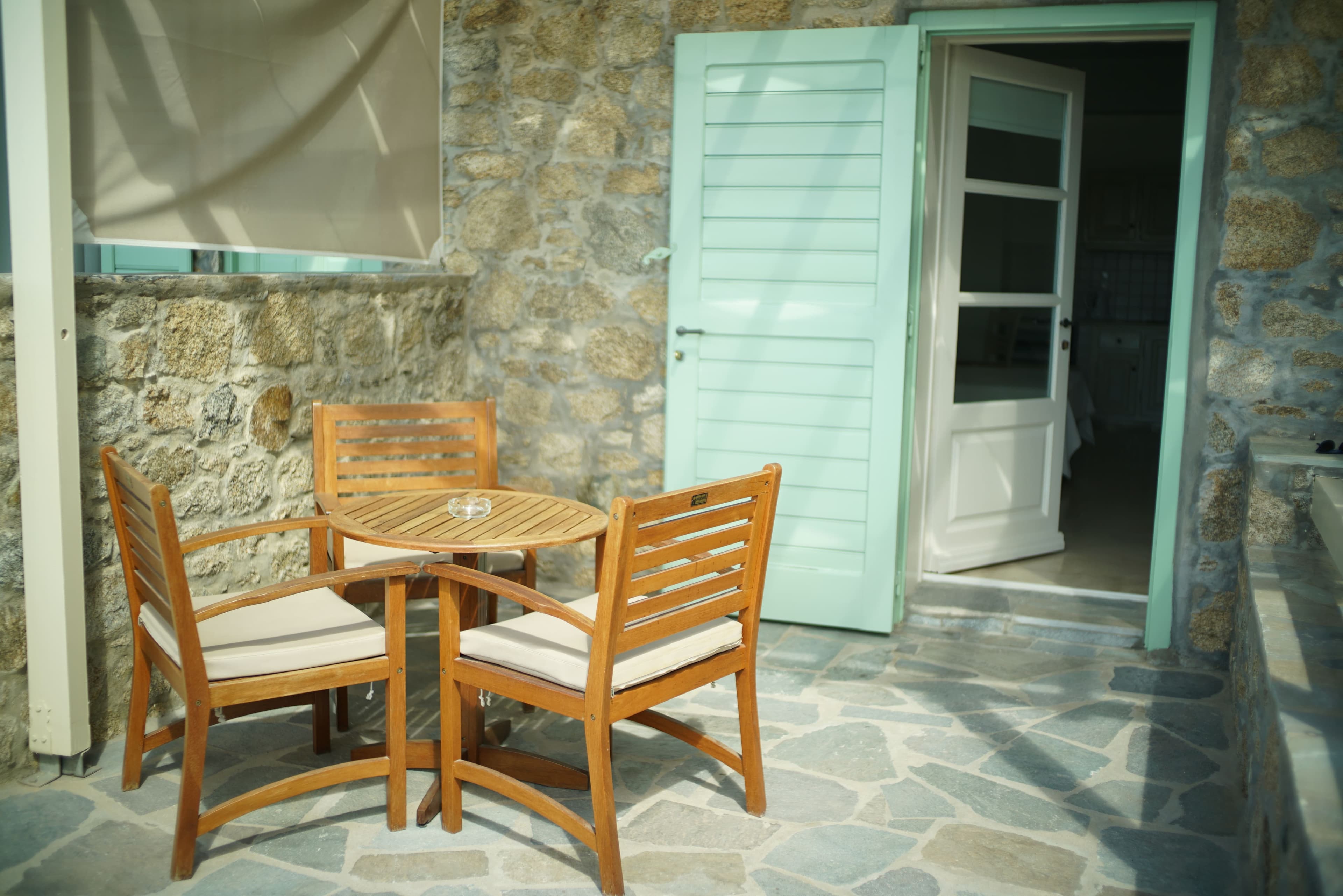 Outdoor table and chairs beside green studio doors