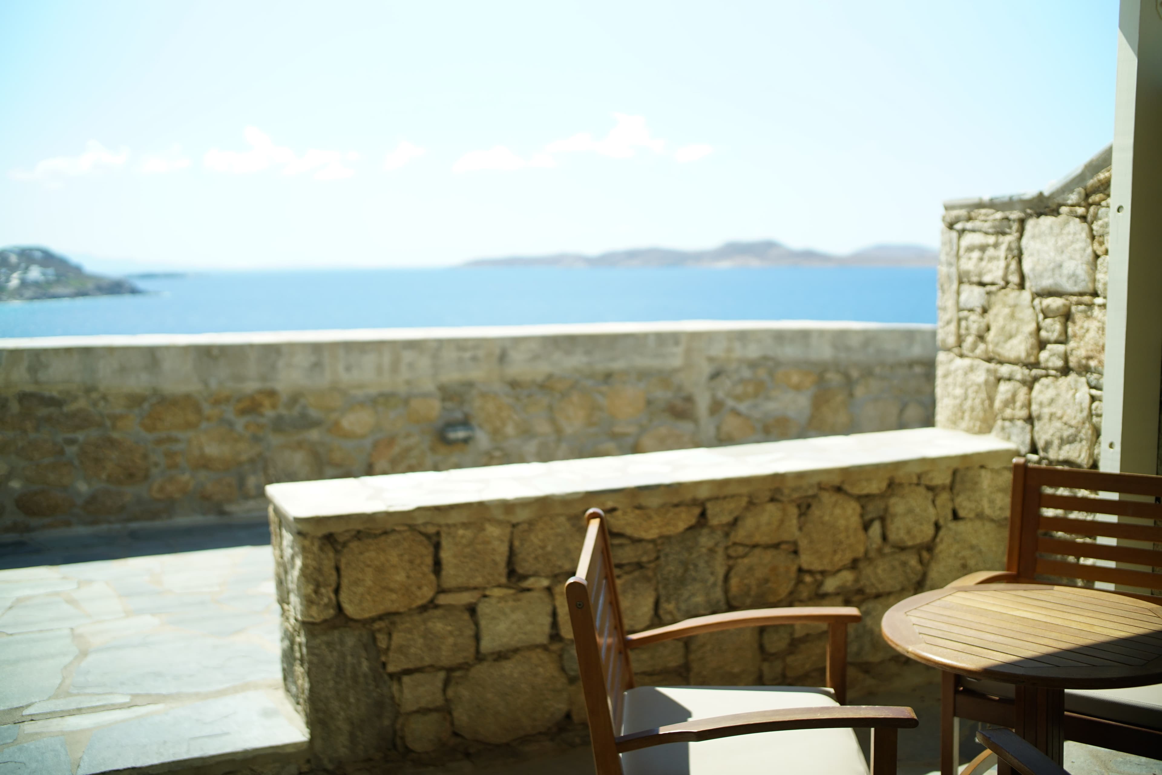 Outdoor chair beside a stone wall overlooking the sea